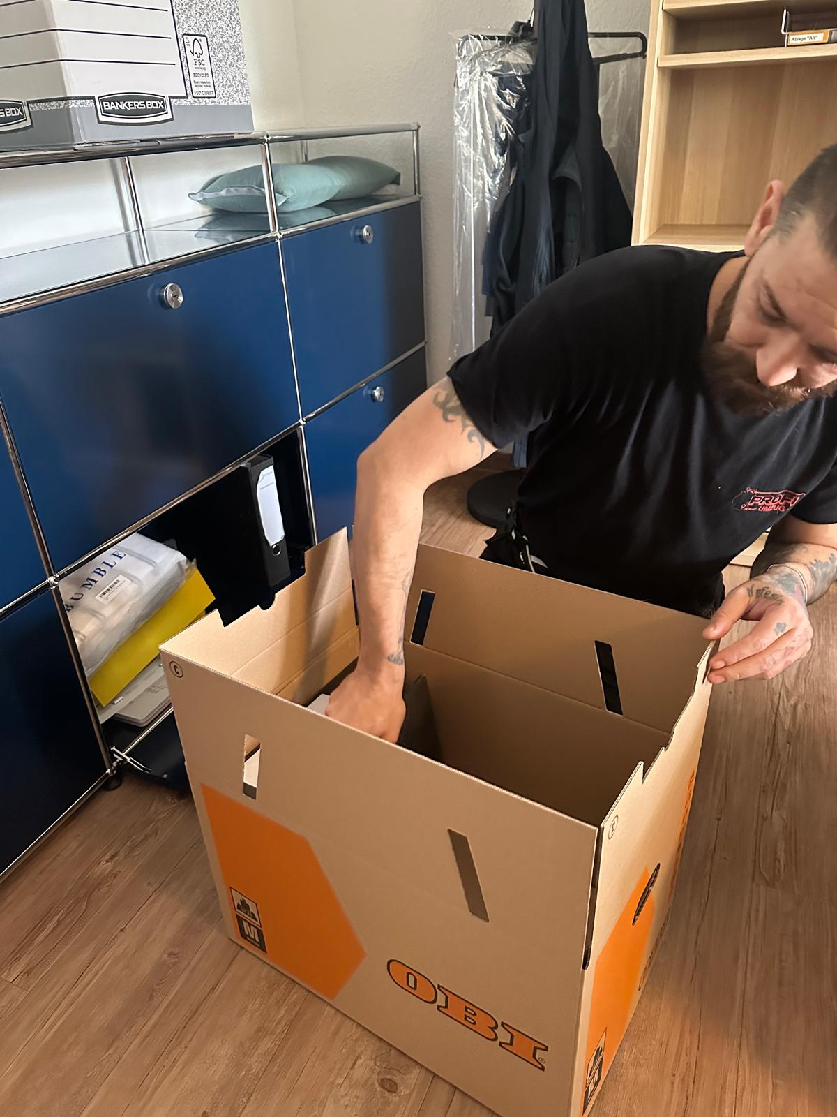 Umzugshelfer beim professionellen Einpacken eines Büros